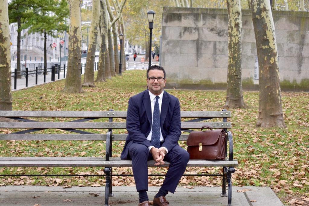 Mr. Cohen sitting on a park-bench looking calm and confidente